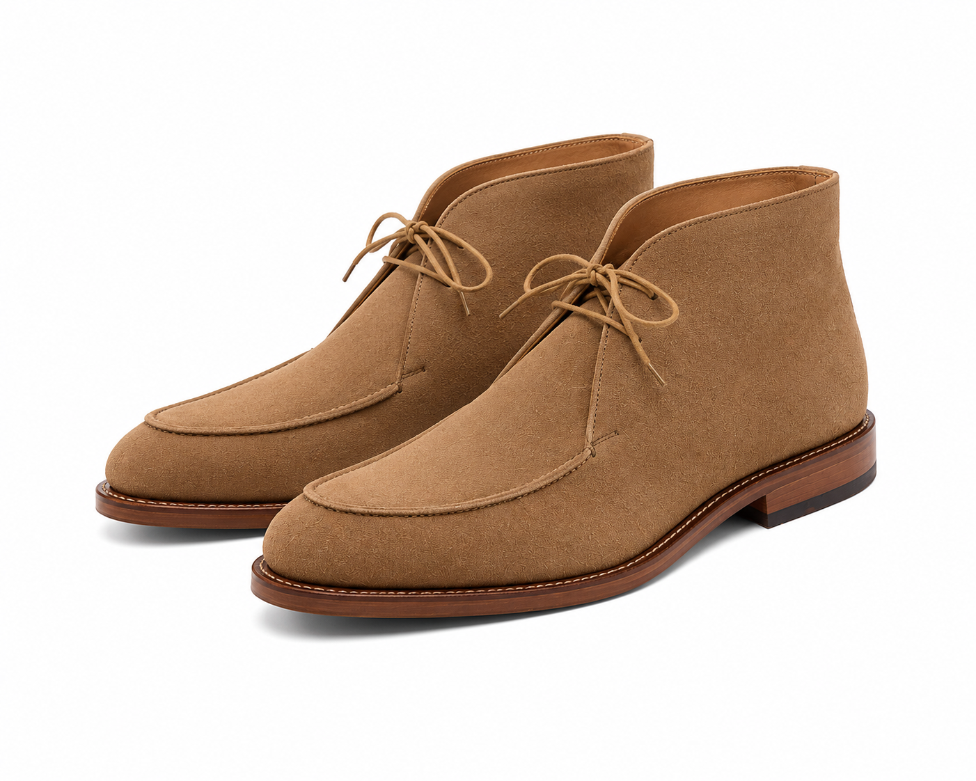 A pair of tan suede chukka boots with matching laces, displayed on a clean white background.
