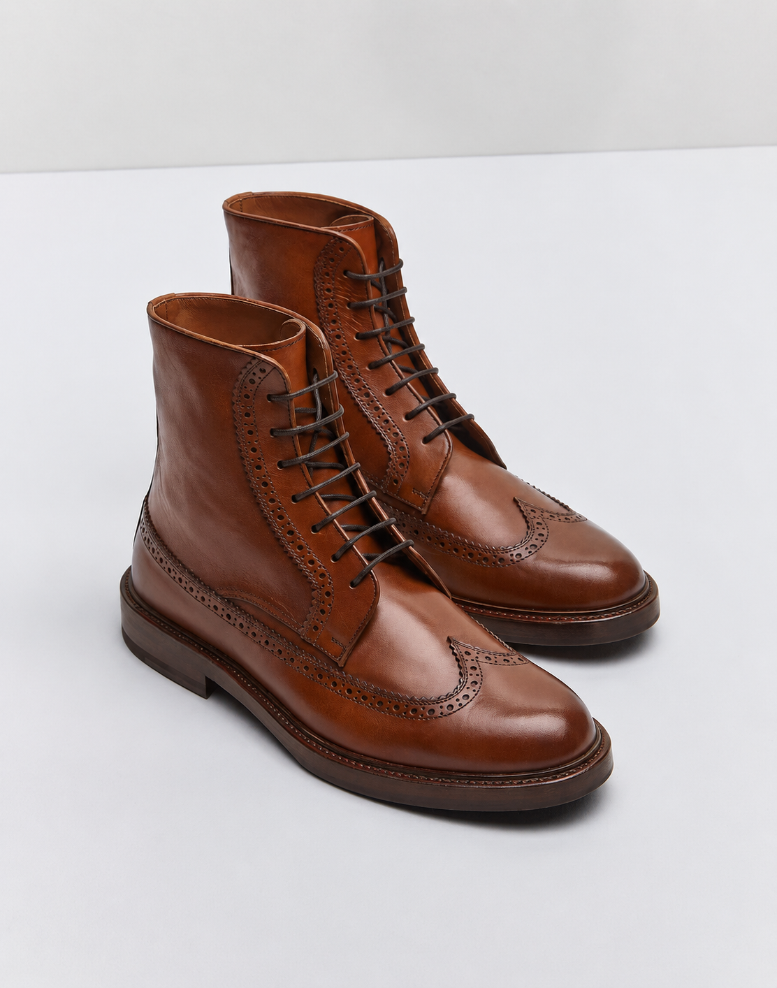 Pair of brown leather boots on a white background