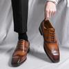 Brown leather dress shoes being worn with a plain background