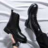 Men's Titan Black Combat Boots crafted from premium leather with lace-up fastening and rugged lug soles, shown in a modern studio setting with one boot held in hand and the other worn for a stylish lifestyle presentation.