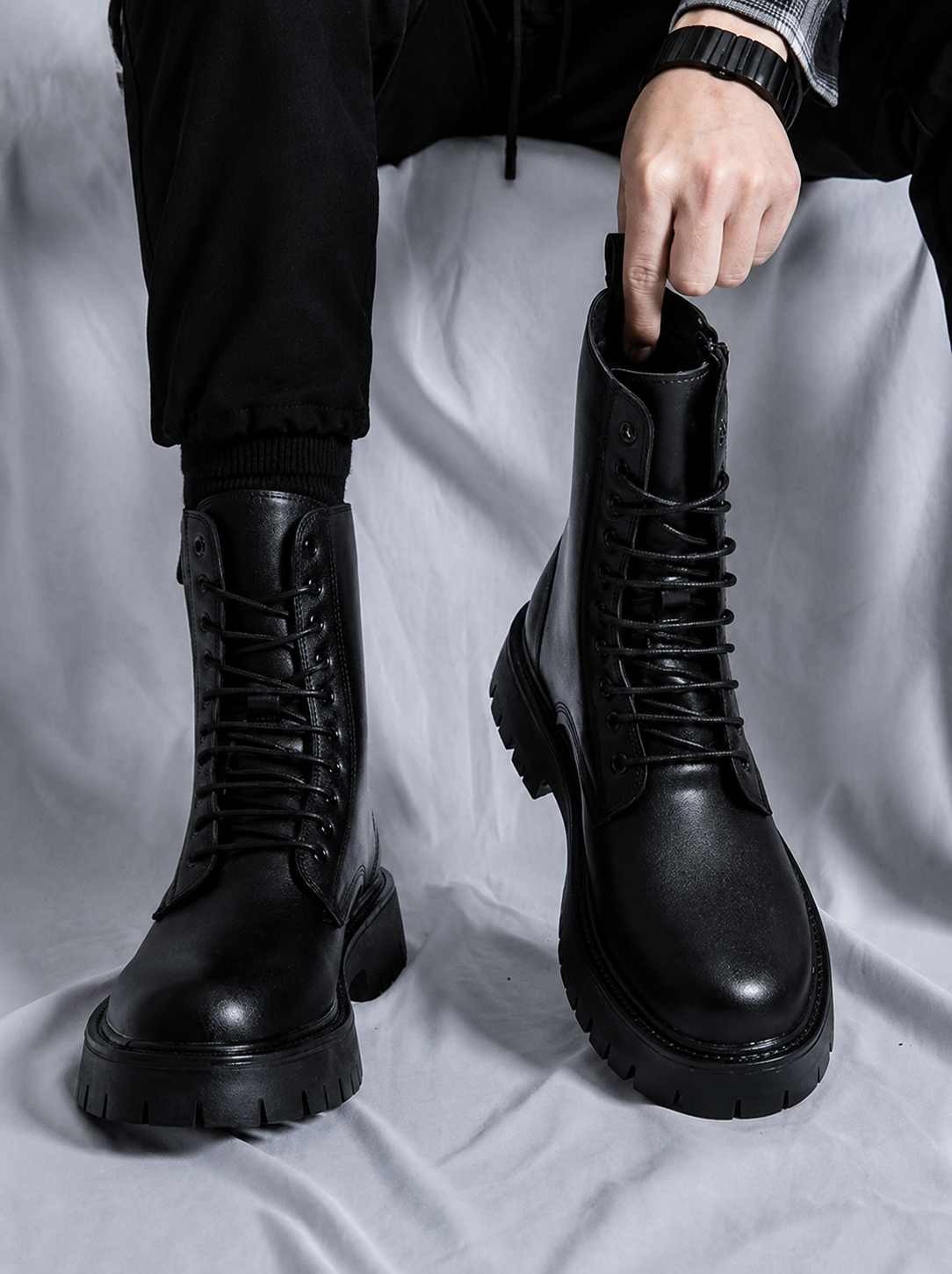 Men's Vanguard Black Combat Boots crafted from premium leather with lace-up closure and rugged lug soles, styled with black cargo pants in a modern streetwear fashion look.