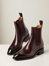 Pair of brown leather Chelsea boots on a light background