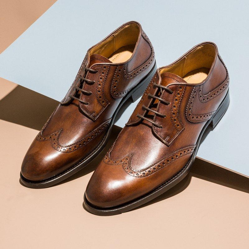 Brown leather dress shoes on a multicolored background