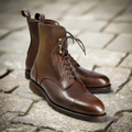 Pair of brown leather boots on a stone pavement