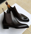 Pair of black leather Chelsea boots on a white surface