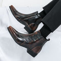 Brown leather boots worn with black pants on a white background