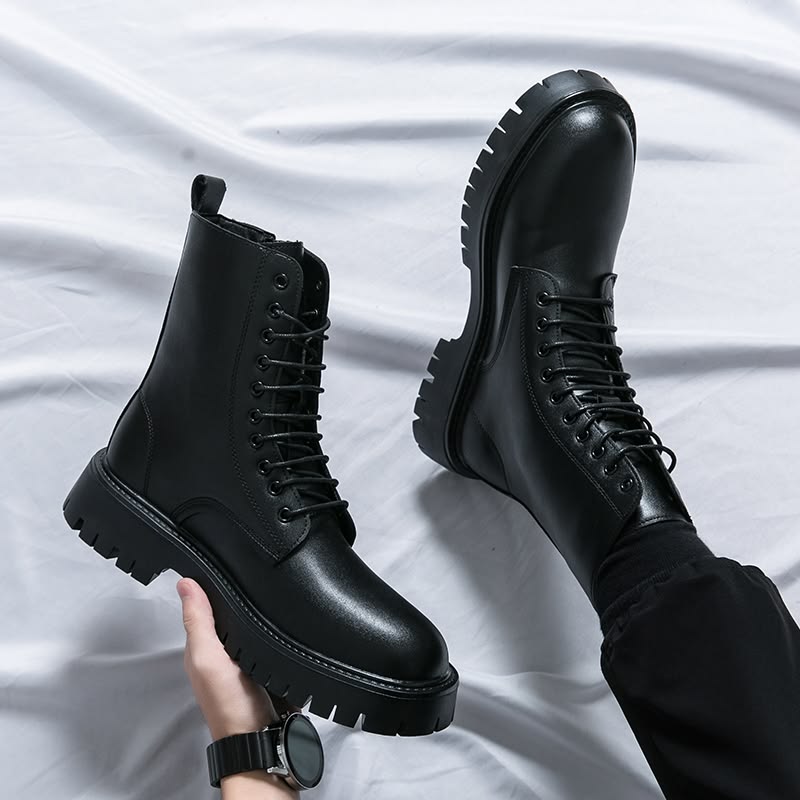 Black leather boots on a white fabric background