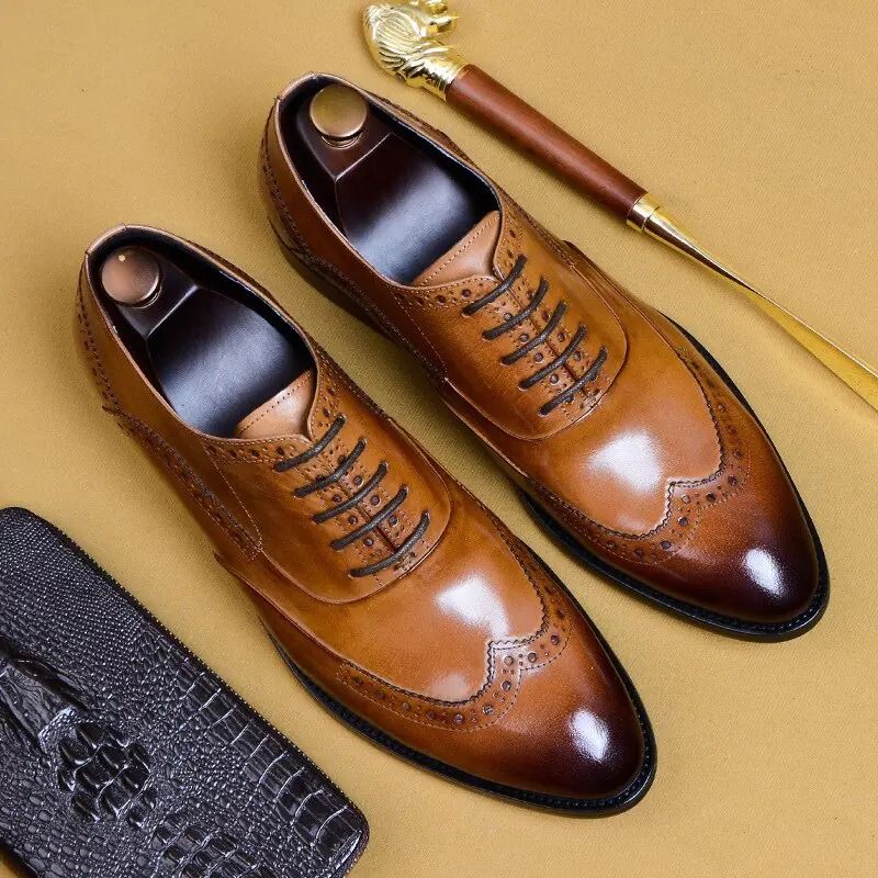 Brown leather dress shoes on a beige background with a shoe brush and black shoe box.
